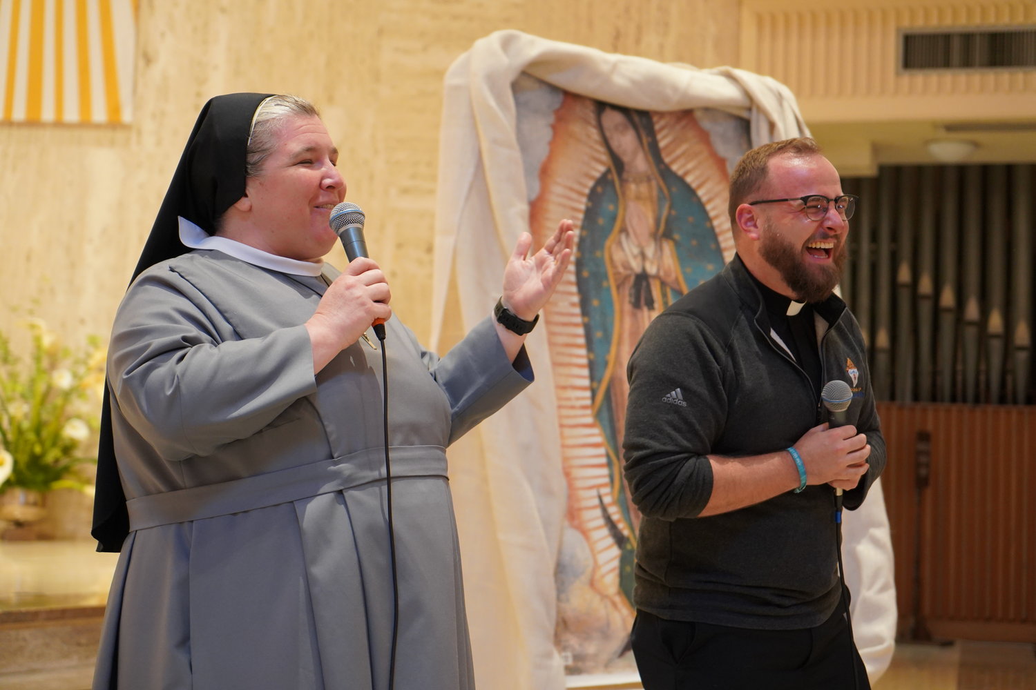 Keynote presenters Sister M. Karolyn Nunes of the Sisters of St. Francis of the Martyr St. George and Father Paul Clark share a funny story during this year’s Sixth- and Seventh-Grade Vocation Day.
